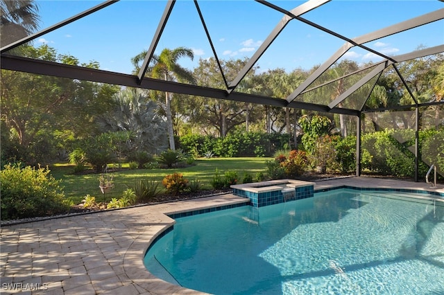 view of pool with an in ground hot tub, a yard, a patio area, and glass enclosure