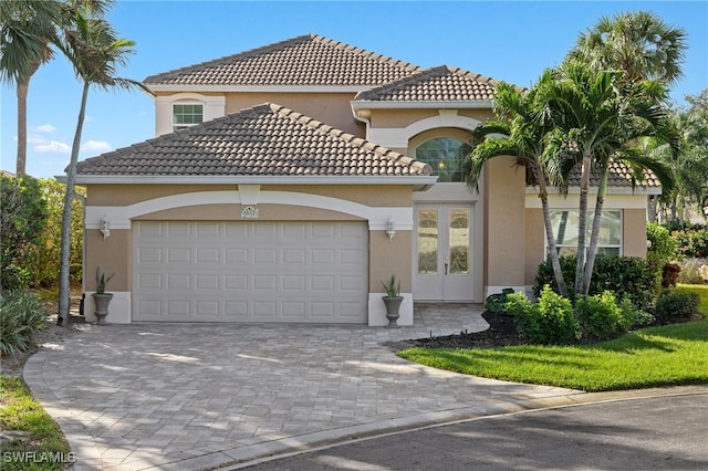 3517 Heron Glen Ct, Bonita Springs, FL 34134 - mediterranean / spanish-style home featuring an attached garage, driveway, stucco siding, and a tile roof