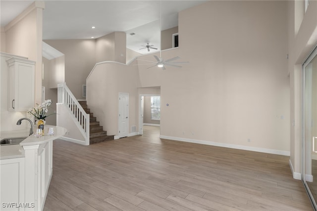 foyer featuring sink, light hardwood / wood-style flooring, high vaulted ceiling, and ceiling fan