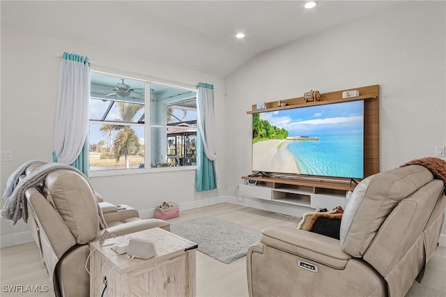 living room featuring ceiling fan, light wood-type flooring, and vaulted ceiling