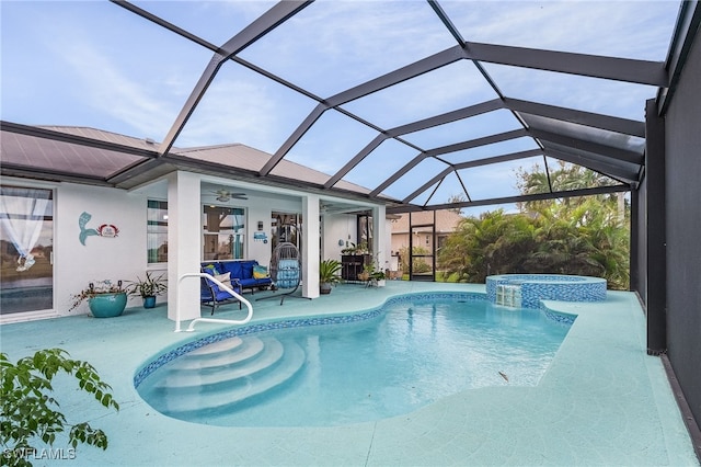 view of swimming pool with a patio area, ceiling fan, and glass enclosure