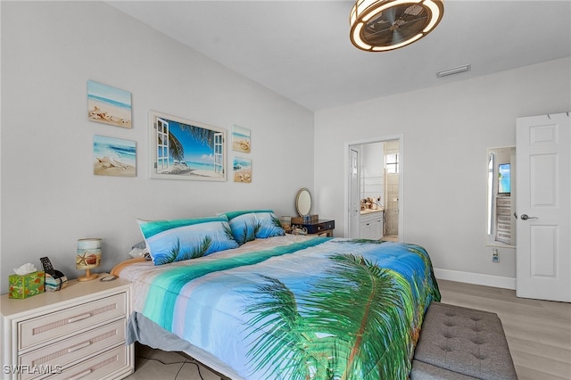 bedroom with ensuite bathroom and light hardwood / wood-style flooring