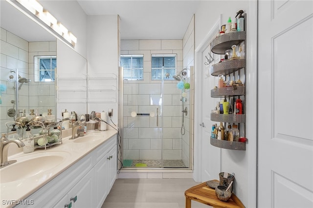 bathroom featuring a shower with door, vanity, and tile patterned flooring