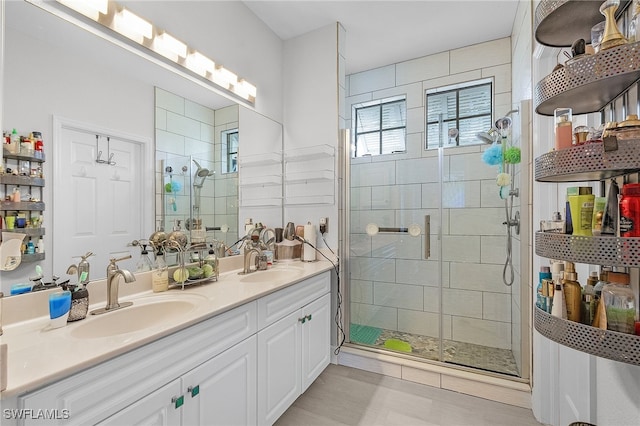 bathroom with a shower with door and vanity