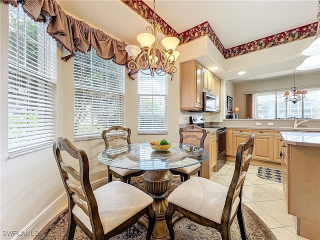 tiled dining space featuring sink, an inviting chandelier, and a healthy amount of sunlight