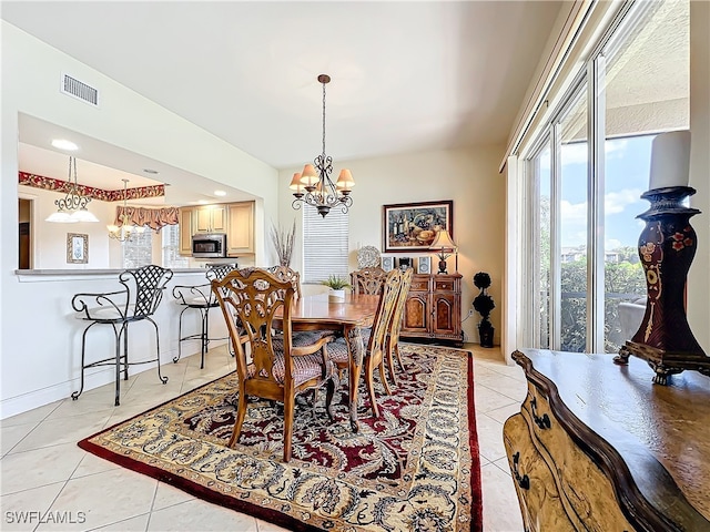 tiled dining room with a chandelier