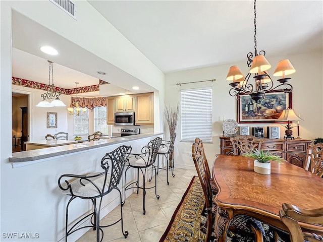 dining area featuring a notable chandelier and light tile patterned flooring