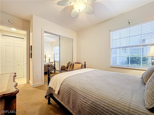 bedroom with ceiling fan, a closet, and light colored carpet