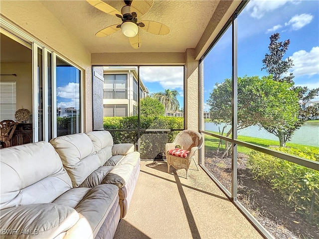 sunroom / solarium featuring a water view and ceiling fan