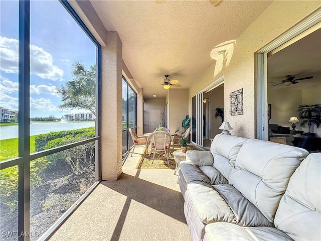 sunroom / solarium with a water view and ceiling fan