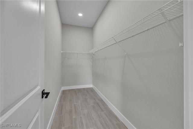 walk in closet with light hardwood / wood-style flooring