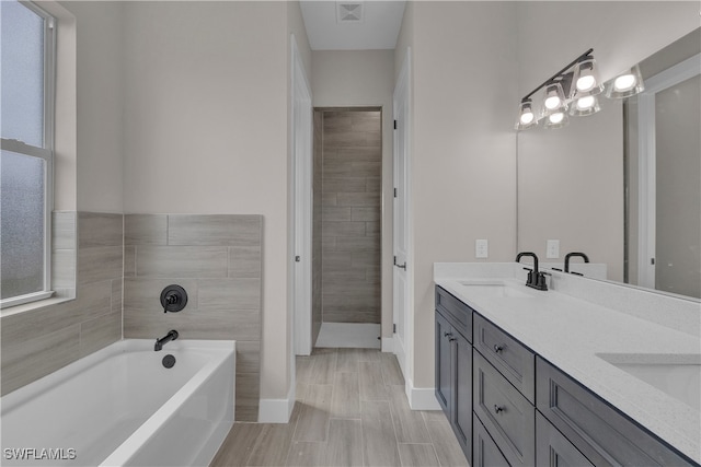 bathroom with vanity, hardwood / wood-style floors, and a bath