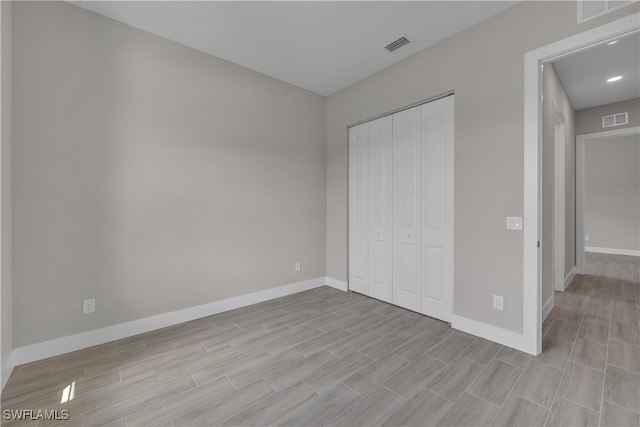 unfurnished bedroom featuring a closet and light hardwood / wood-style flooring