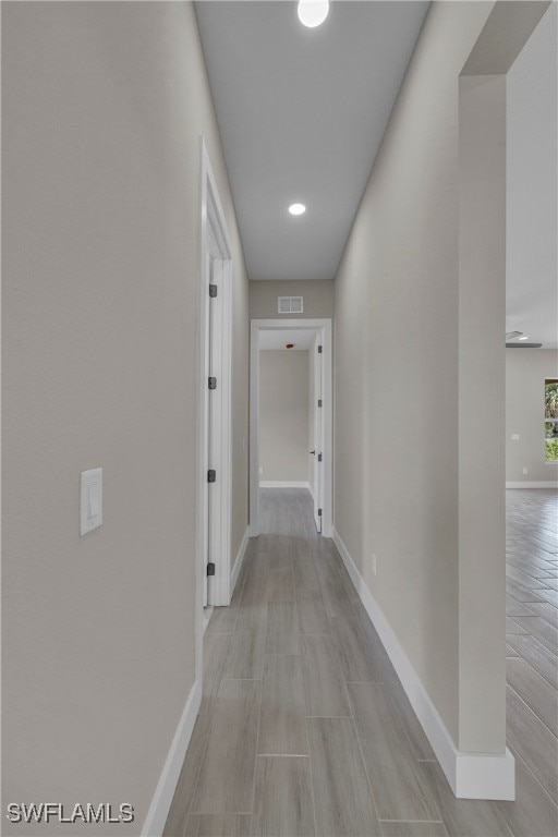 corridor with light hardwood / wood-style floors