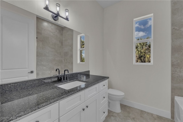 bathroom with vanity, a tub to relax in, toilet, and tile patterned floors