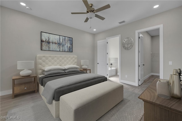 bedroom featuring ceiling fan, a spacious closet, connected bathroom, light wood-type flooring, and a closet