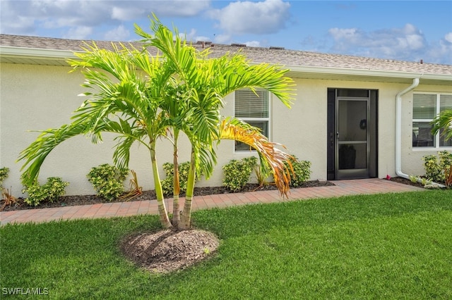 view of exterior entry featuring a yard