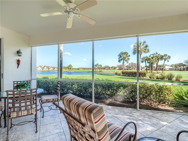 sunroom with a water view and ceiling fan