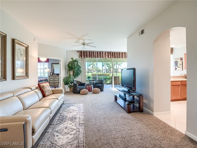 living room featuring ceiling fan, a healthy amount of sunlight, and light colored carpet