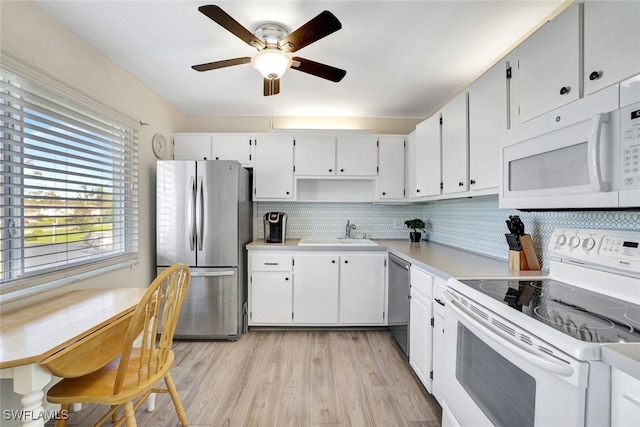 kitchen featuring appliances with stainless steel finishes, white cabinetry, decorative backsplash, and sink