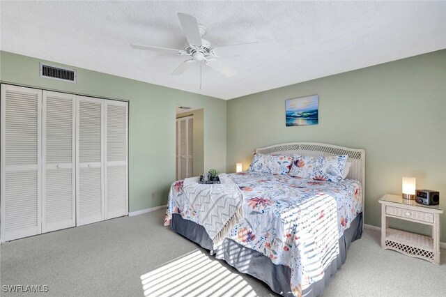 bedroom featuring ceiling fan, carpet floors, and a textured ceiling