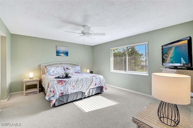 carpeted bedroom featuring a textured ceiling and ceiling fan