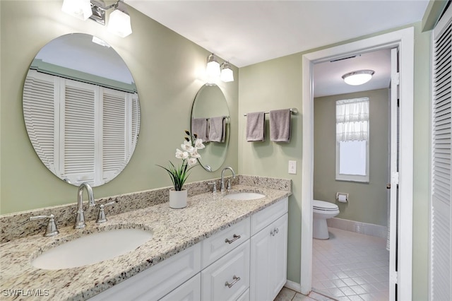 bathroom featuring toilet, tile patterned floors, and vanity