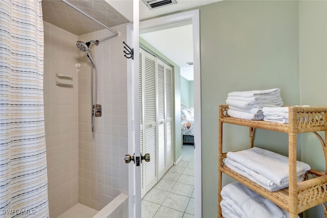 full bathroom featuring a tile shower, visible vents, and tile patterned floors