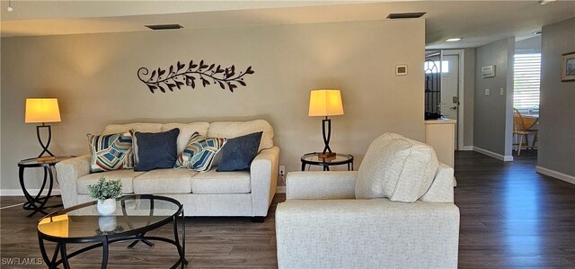 living area featuring baseboards and dark wood-style flooring