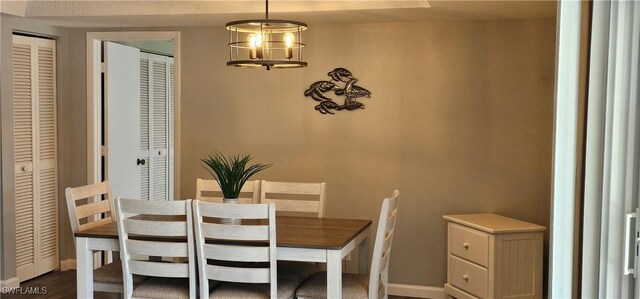 dining room featuring an inviting chandelier and baseboards