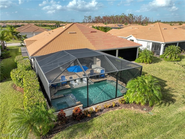 view of pool with a lanai, a lawn, a patio, and an in ground hot tub