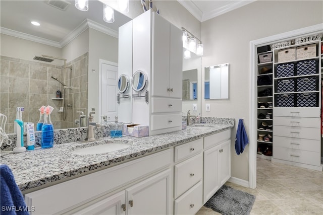 bathroom featuring ornamental molding, vanity, tile patterned floors, and tiled shower