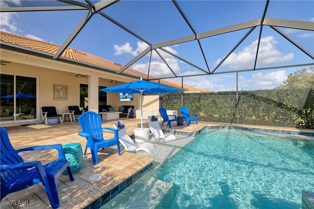 view of pool with ceiling fan, a lanai, and a patio