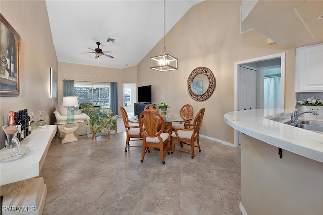 dining area featuring high vaulted ceiling, sink, and ceiling fan with notable chandelier