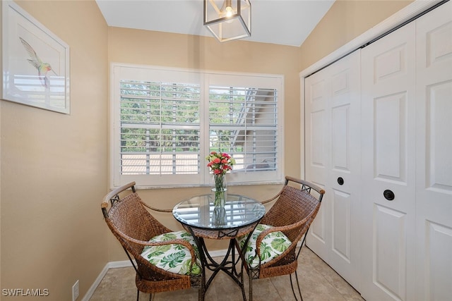 dining space with vaulted ceiling and light tile patterned floors