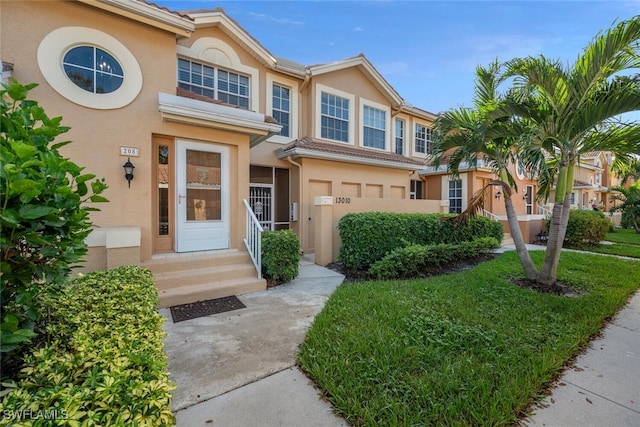 13010 Amberley Ct Unit 208, Bonita Springs, FL 34135 - view of property featuring stucco siding, entry steps, and an attached garage