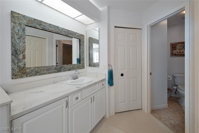 bathroom featuring vanity, toilet, and tile patterned floors