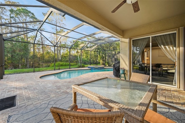 view of pool with a lanai, a patio area, an in ground hot tub, and ceiling fan