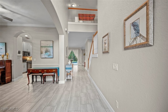 hallway with light hardwood / wood-style flooring and ornamental molding