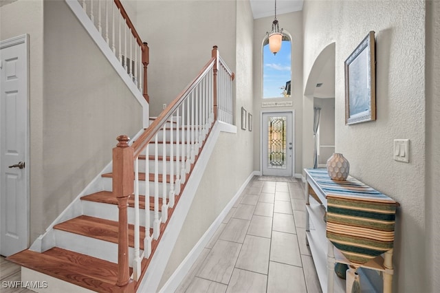 entryway with a high ceiling and a notable chandelier