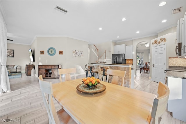 dining space featuring ceiling fan, light hardwood / wood-style floors, and ornamental molding