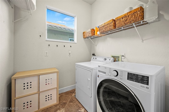 washroom with separate washer and dryer and dark tile patterned flooring