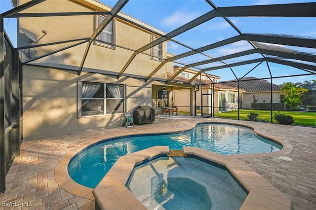 view of swimming pool with a lanai, a patio area, and an in ground hot tub