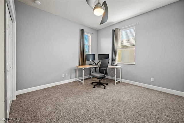 carpeted home office featuring ceiling fan