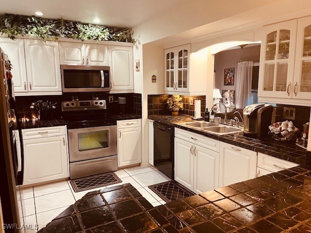 kitchen with decorative backsplash, stainless steel appliances, and white cabinetry