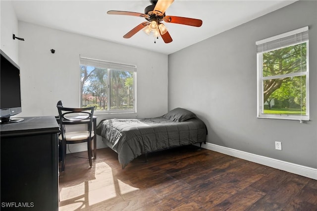 bedroom with multiple windows, ceiling fan, and dark wood-type flooring