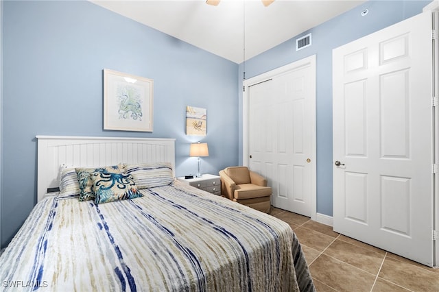 bedroom featuring light tile patterned flooring, ceiling fan, and a closet