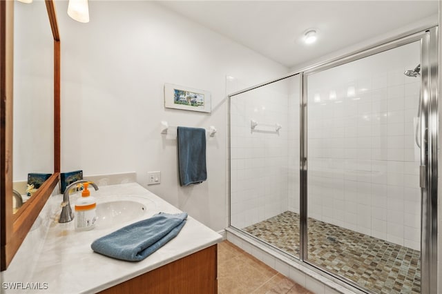 bathroom featuring vanity, a shower with shower door, and tile patterned floors