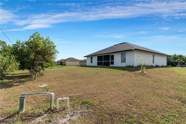 2918 12th St SW, Lehigh Acres, FL 33976 - rear view of house featuring stucco siding and a yard