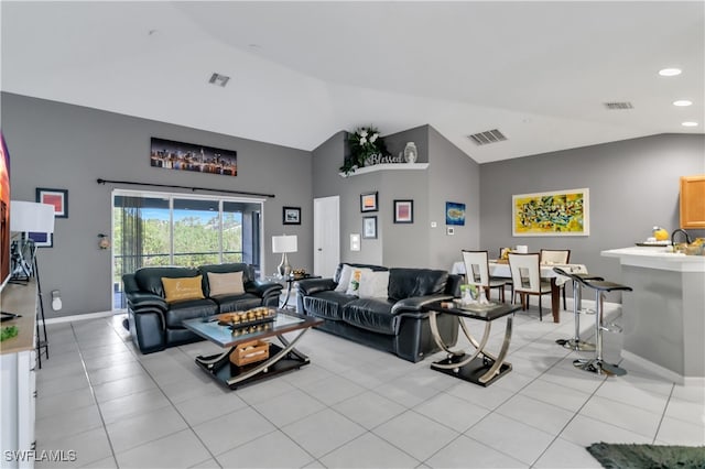 living room with sink, vaulted ceiling, and light tile patterned floors